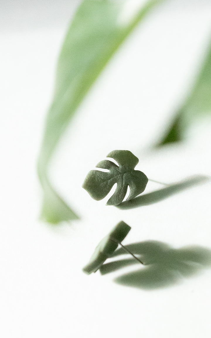 Vue de face des puces d’oreilles en forme de feuille de Monstera, modèle MAUI. Leur design épuré met en valeur les nervures stylisées de la feuille, symbole de fraîcheur et de style botanique.
Chaque boucle est imprimée en 3D à partir de nylon recyclé, puis teintée à la main dans une douce teinte de vert végétal. Un bijou minimaliste, ultraléger et fait au Québec, parfait pour un look naturel et contemporain.