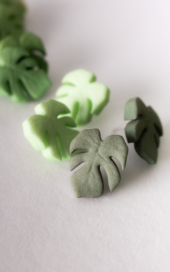 Vue de face des puces d’oreilles en forme de feuille de Monstera, modèle MAUI. Leur design épuré met en valeur les nervures stylisées de la feuille, symbole de fraîcheur et de style botanique.
Chaque boucle est imprimée en 3D à partir de nylon recyclé, puis teintée à la main dans une douce teinte de vert végétal. Un bijou minimaliste, ultraléger et fait au Québec, parfait pour un look naturel et contemporain.