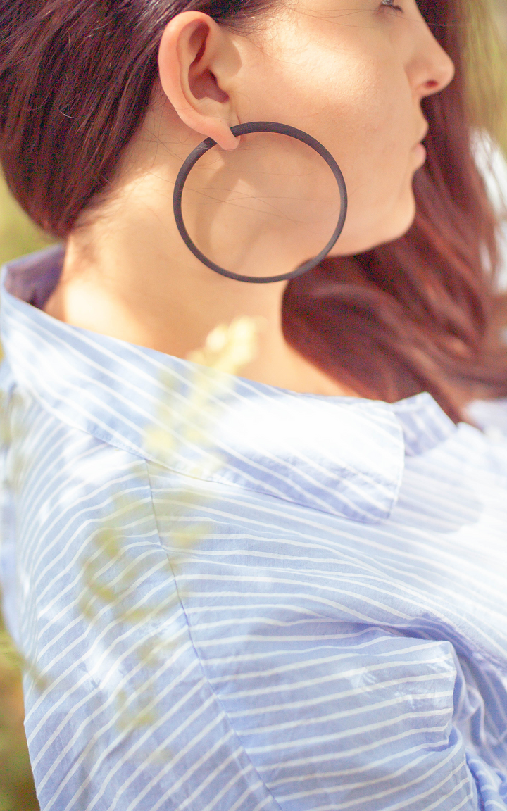 Les anneaux Atlas 8 cm jeune femme porte un anneau a l'oreille.. Couleur noir.