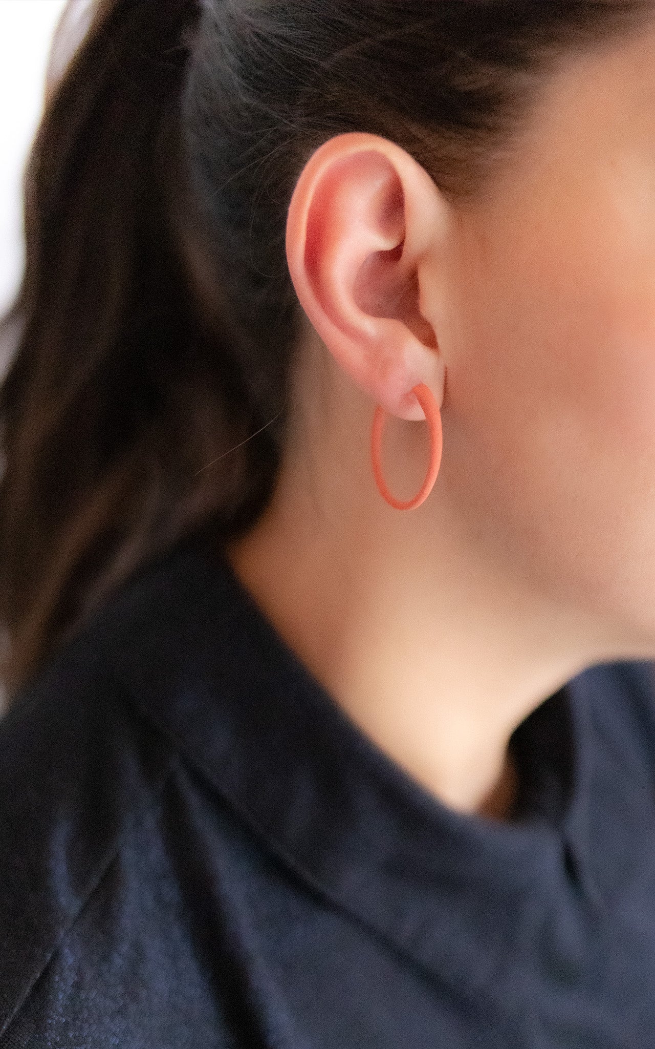 Anneaux d'oreilles , boucles D'oreilles rondes porté par une jeune femme, Bijou orange.