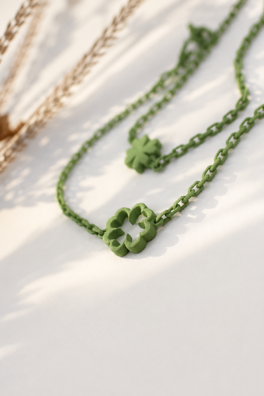 Bracelet d'amitié Trèfle vert Vox & Oz avec trèfle à quatre feuilles. Bijou ultraléger en nylon recyclé imprimé en 3D, fabriqué au Québec, présenté dans une douce lumière matinale.