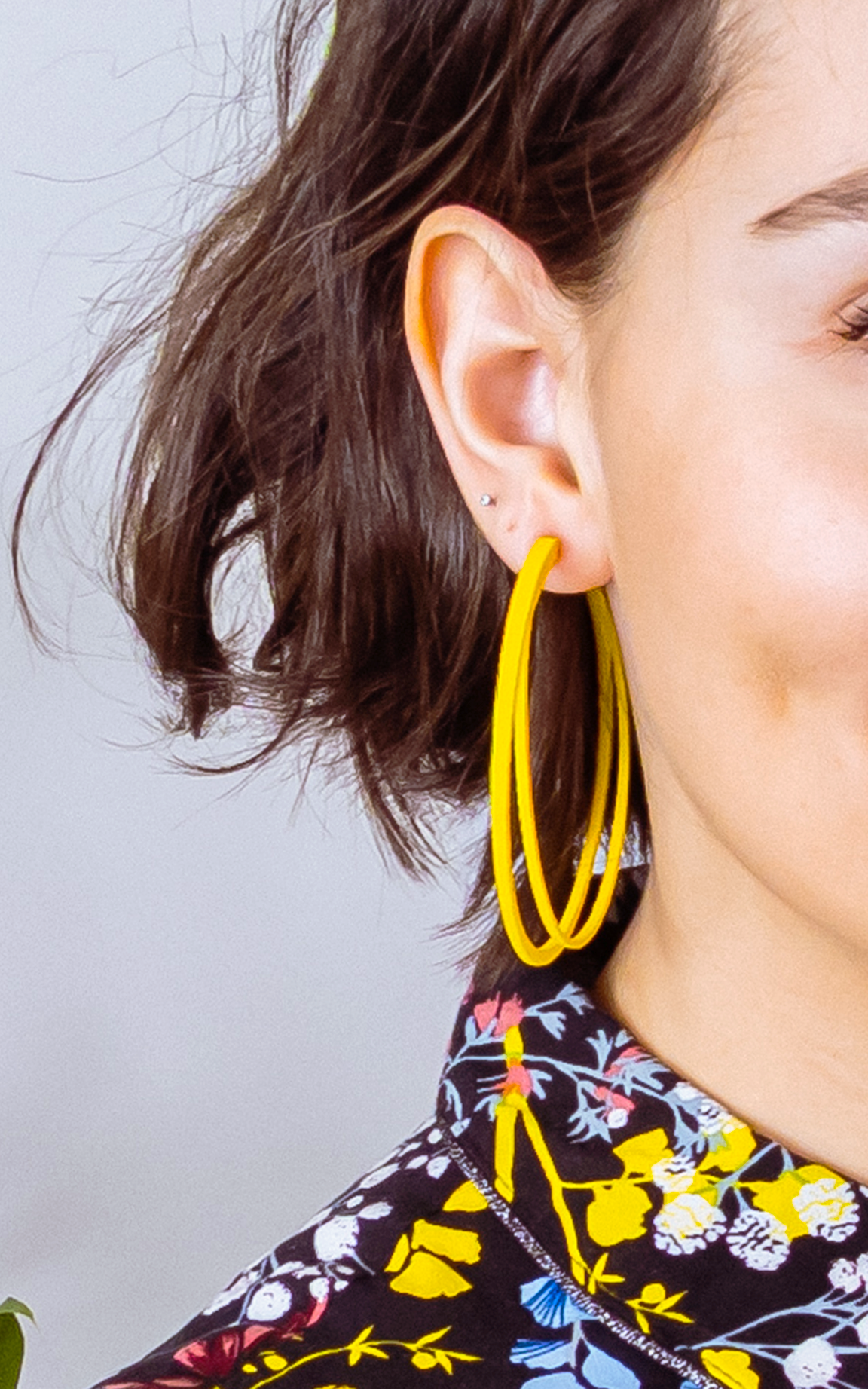 Grands anneaux d'oreilles jaune ultralégers  de la collection Vox & OZ et femme aux cheveux bruns